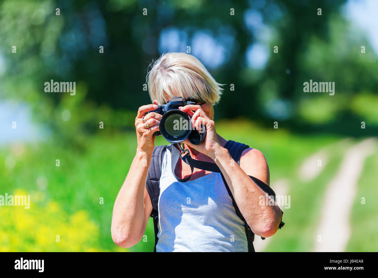 Reife Frau mit einer Kamera fotografieren, während einer Wanderung Stockfoto