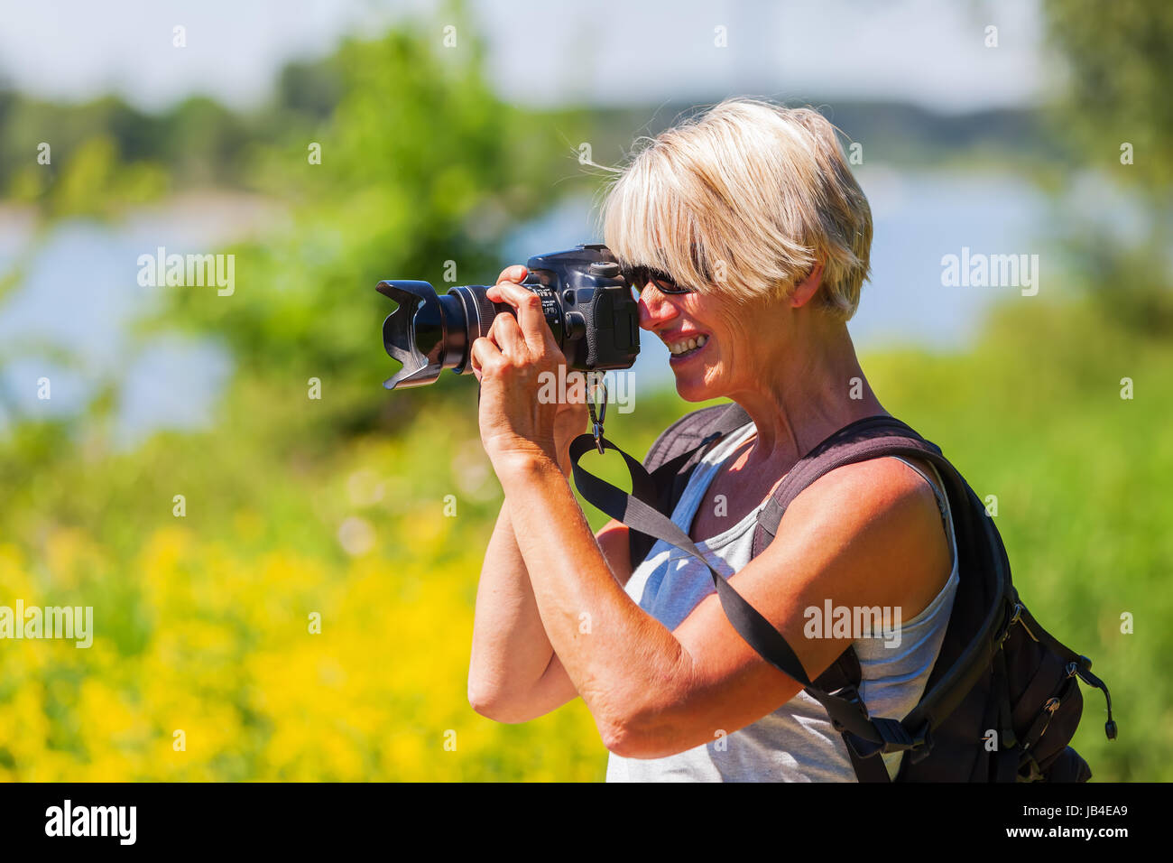 Reife Frau mit einer Kamera fotografieren, während einer Wanderung Stockfoto