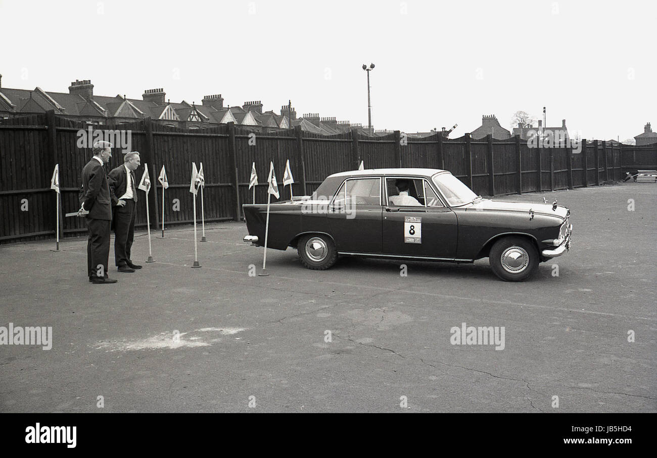 1960er-Jahren, historische, prüfen Driving Prüfer die Umkehrung Technik eines Treibers von einem Ford Zodiac in einem Parkhaus nstige Stadium, Süd-London, an der Fahrschüler of the Year Wettbewerb. Stockfoto