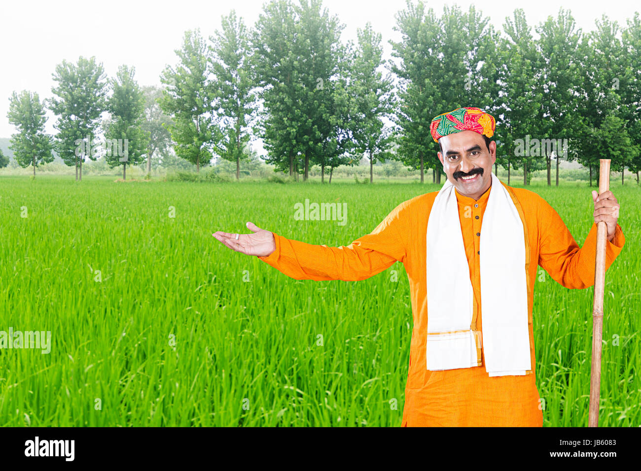 1 Indischen ländlichen Rajasthani Bauer in Hof und deutete mit der Hand ernten. - Landwirtschaft Konzept Stockfoto