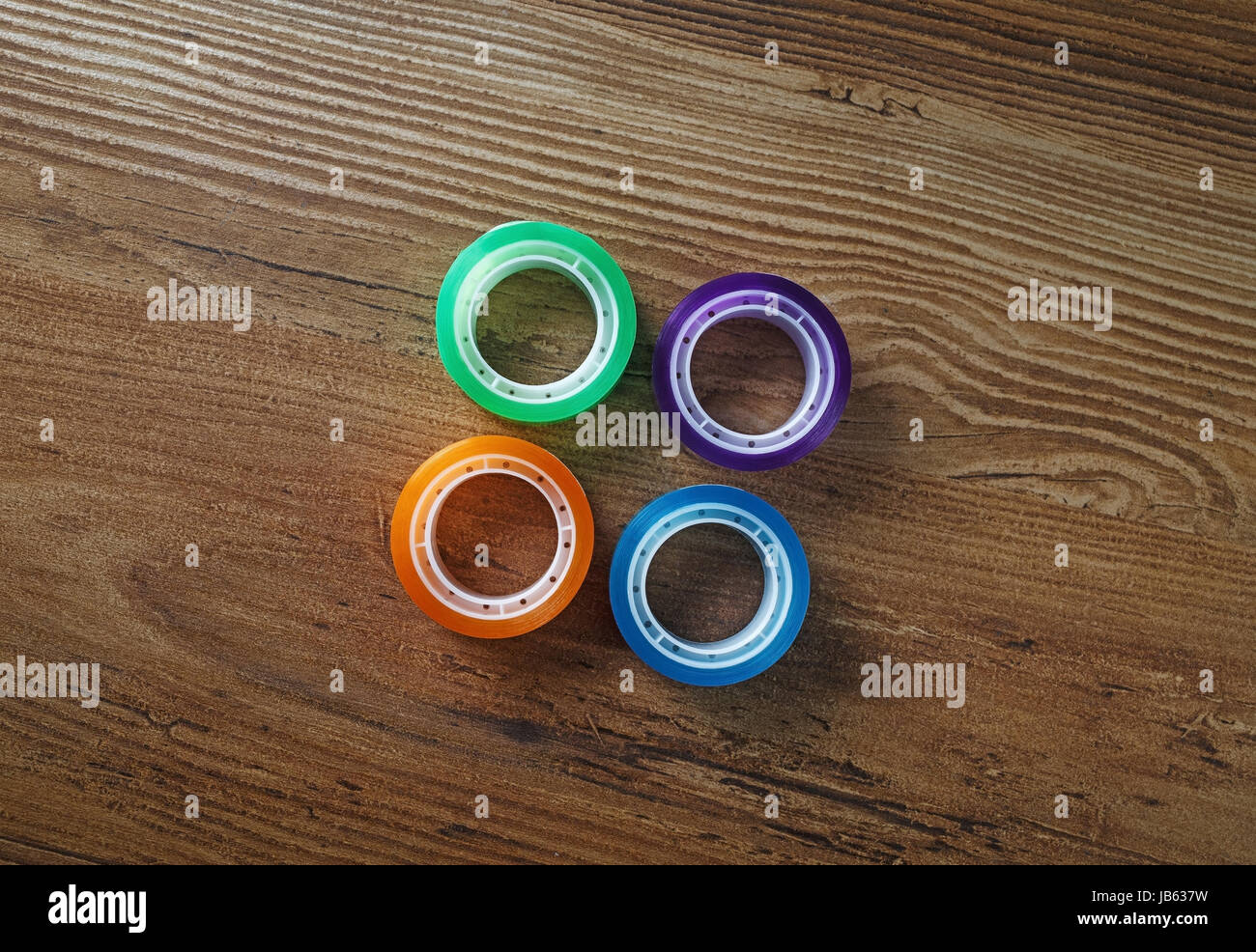 Vier Rollen bunte Tesafilm auf Holztisch Hintergrund. Stockfoto