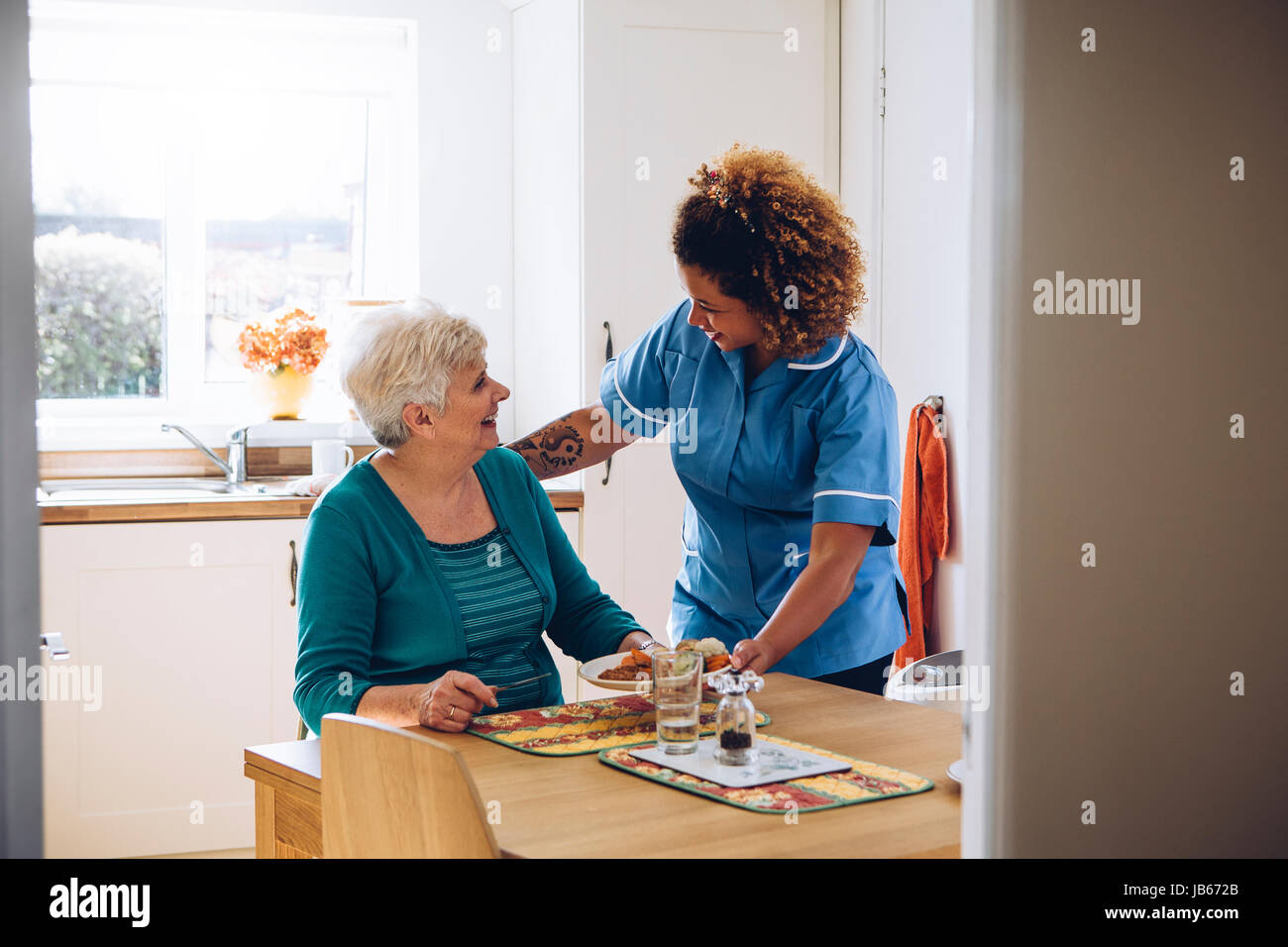 Care Arbeitnehmer geben einer alten Dame ihr Abendessen in ihrem Haus. Stockfoto