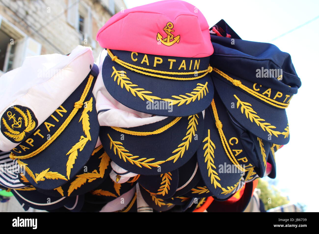 Rosa, blauen und weißen Kapitäne Hüte zu verkaufen mit gold Braid und schwarzen Spitzen und Anker-Motive Stockfoto