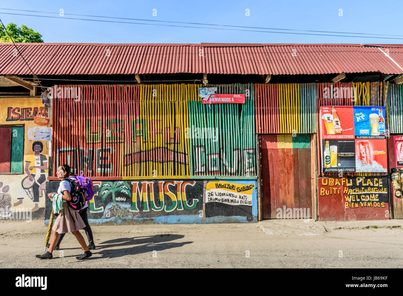 Livingston, Guatemala - 31. August 2016: Mädchen vorbei an bunt bemalte Wände in der Straße in der karibischen Stadt Livingston Stockfoto