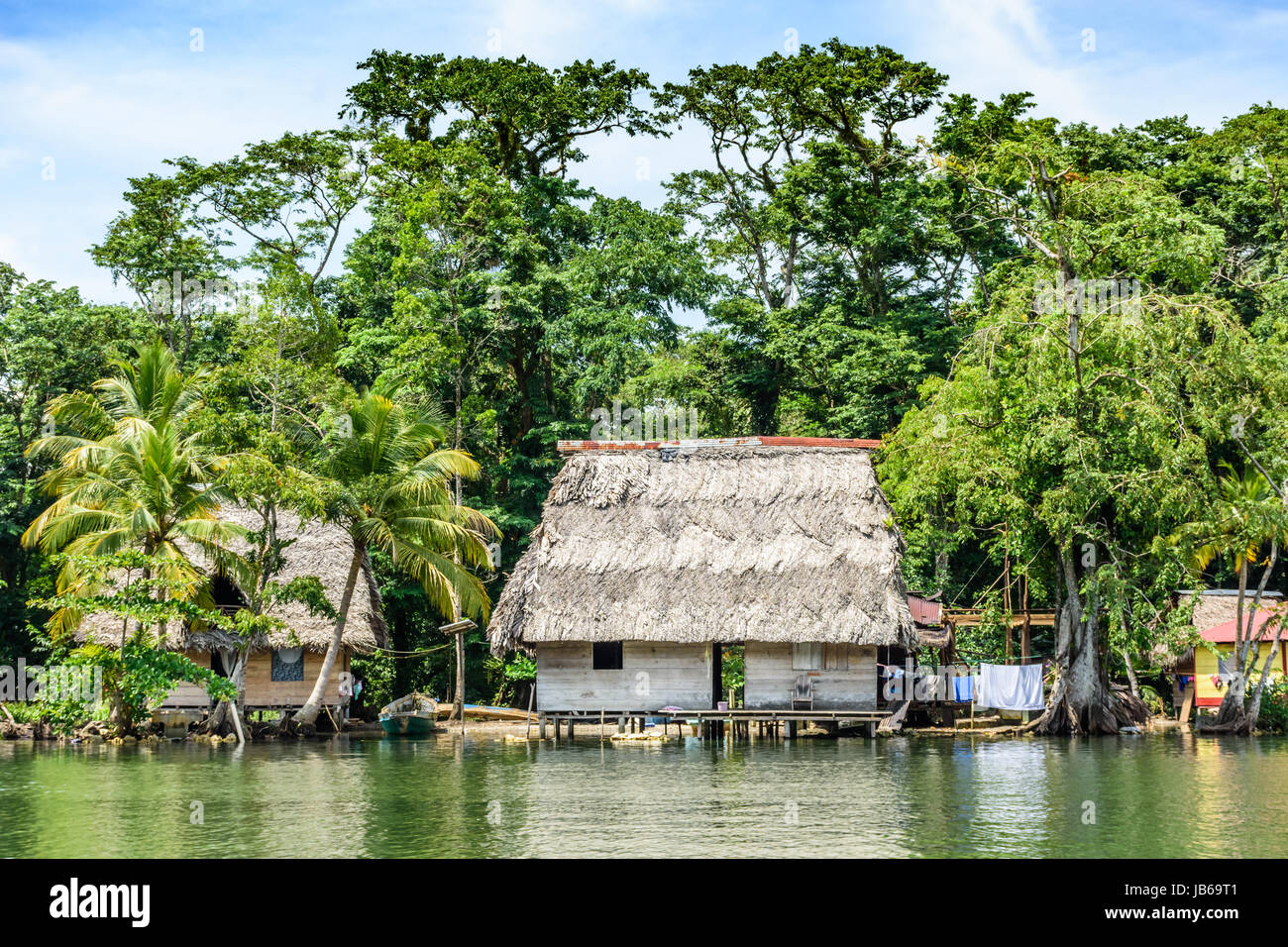 Rio Dulce, Guatemala - September 1, 2016: Holzhäuser auf Stelzen mit palm leaf Dächer am Ufer des Rio Dulce, Guatemala, Mittelamerika Stockfoto