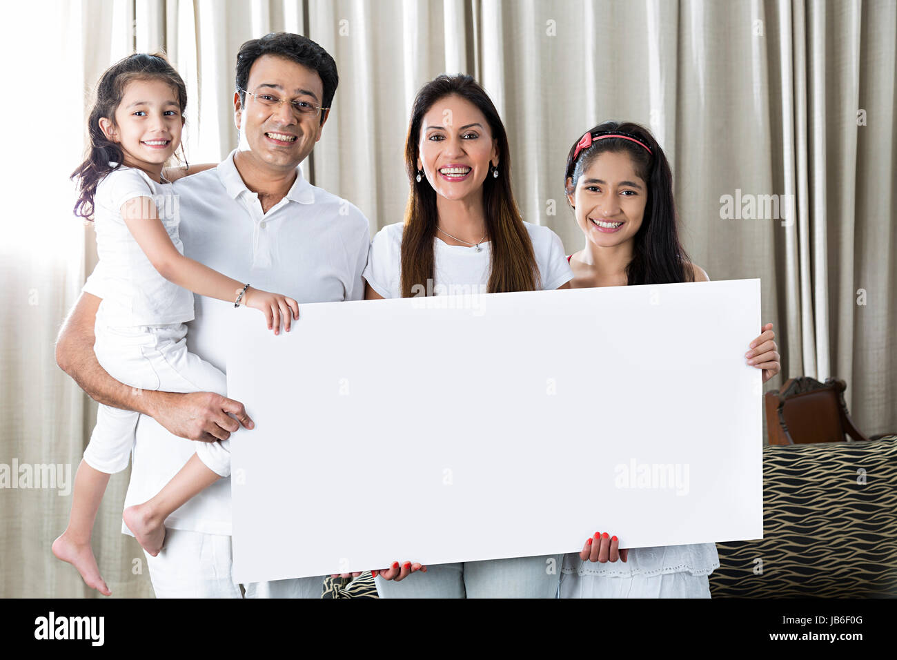 4 Leute, die zu Hause Tochter Mädchen Eltern zeigen lächelnd ständigen Zweisamkeit weiße Gespraechsbedarf Stockfoto