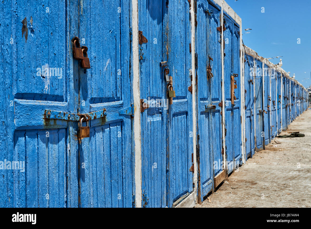 verwitterten blauen Holztüren in Reihe von Fischerei-Ausrüstung-Schuppen Stockfoto