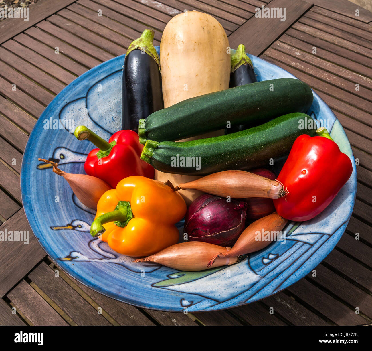 Noch immer leben handgemachte Keramik Schüssel mit frischem Gemüse auf Holz Outdoor Picknick Tisch Stockfoto