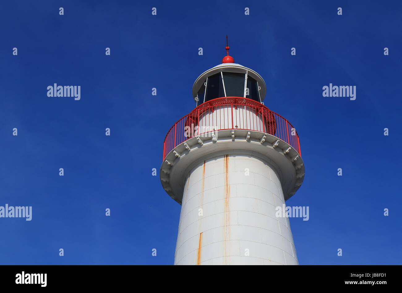 Weißer und roter Leuchtturm im blauen Himmel Stockfoto