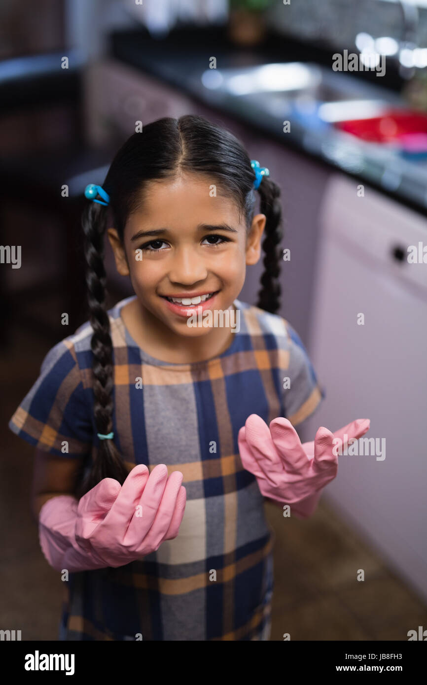 Porträt von lächelndes Mädchen Rosa Gummihandschuhen in Küche zu Hause Stockfoto