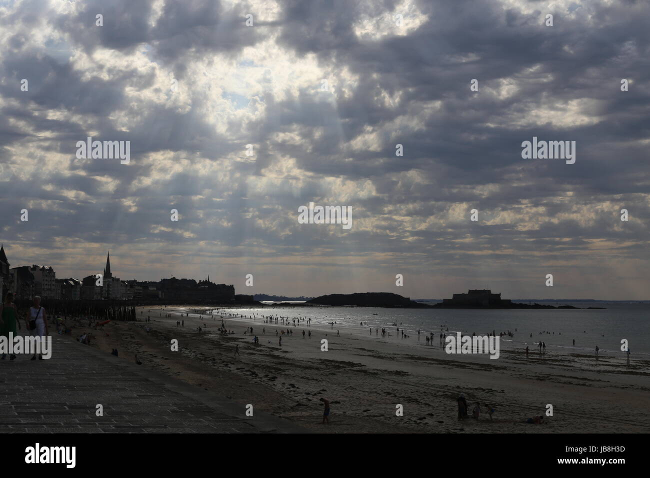 Schöne Strand-Szene am frühen Abend mit Wellen von Licht durch die Wolken in Saint-Malo, Frankreich Stockfoto