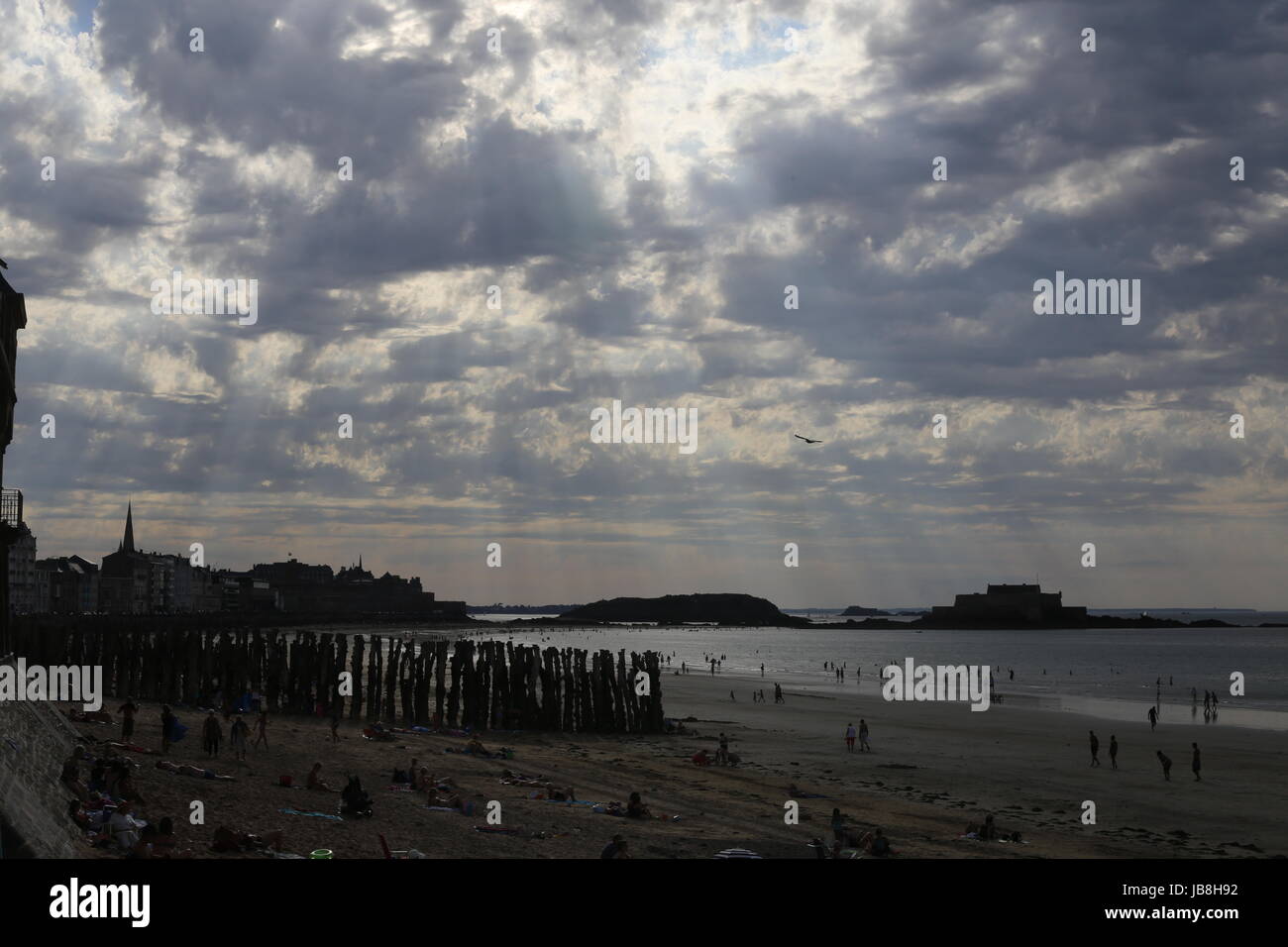 Schöne Strand-Szene am frühen Abend mit Wellen von Licht durch die Wolken in Saint-Malo, Frankreich Stockfoto