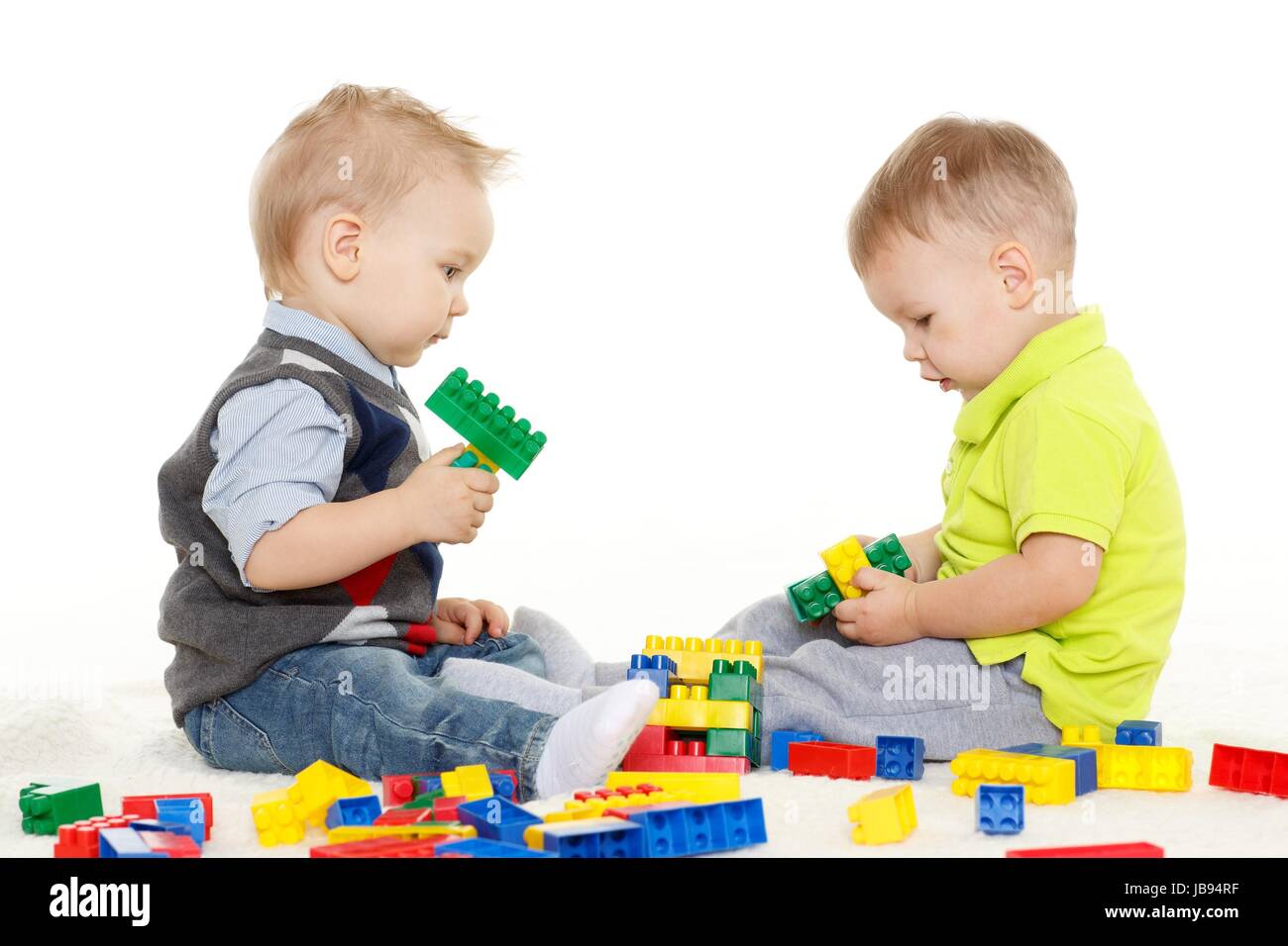 Zwei kleine Jungs spielen mit Spielzeug auf einem weißen Hintergrund zu entwickeln. Stockfoto