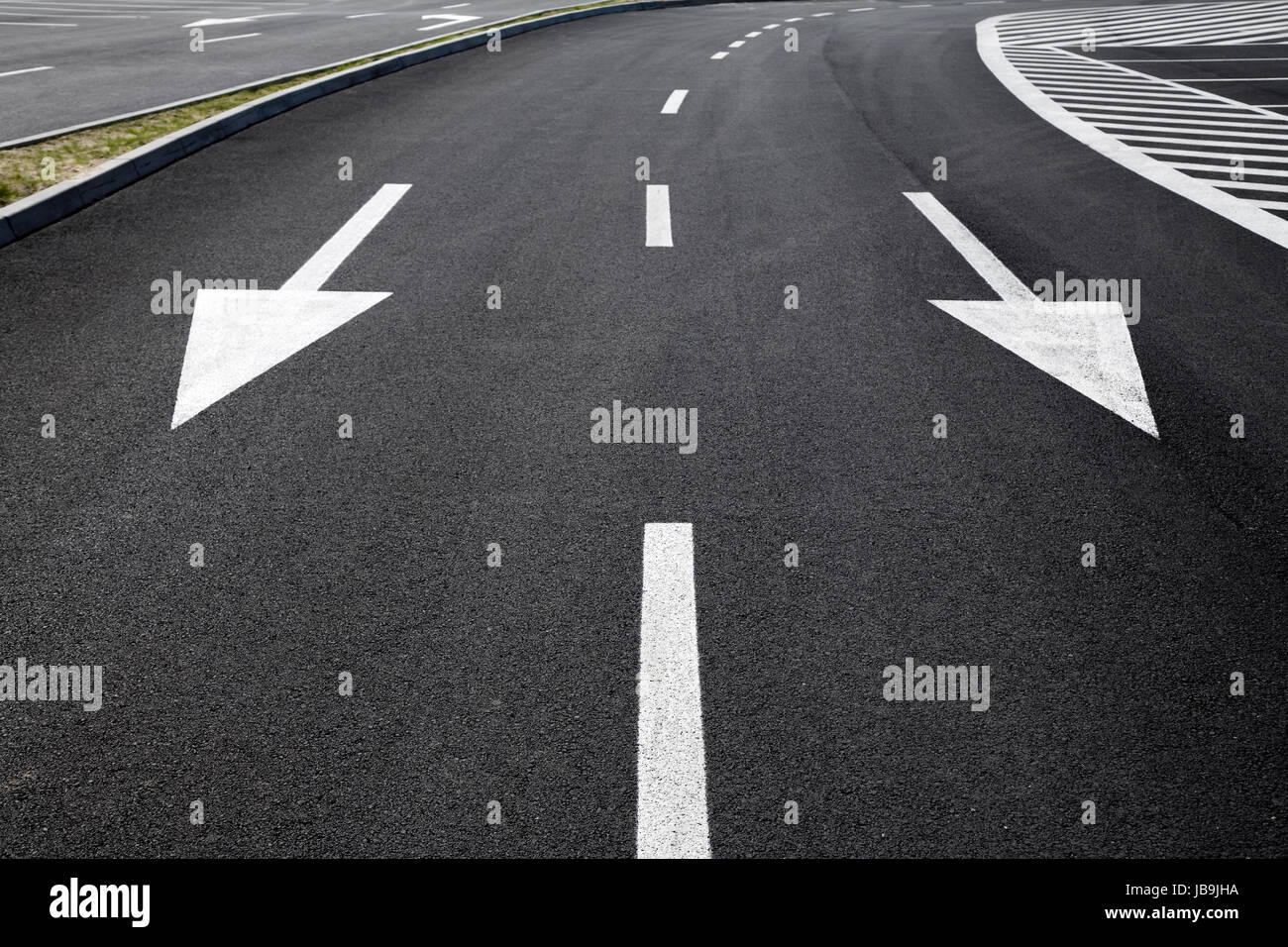 Pfeil-Zeichen als Straßenmarkierungen auf einer Straße Stockfoto