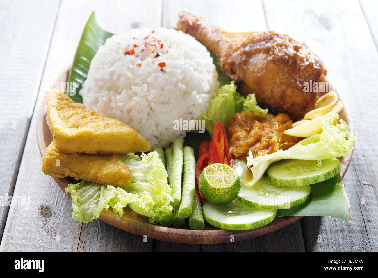 Berühmte traditionelle indonesische Speisen. Köstliches Nasi Ayam Penyet mit Sambal Belacan.  Frisch heiß mit Dampf Rauch. Stockfoto