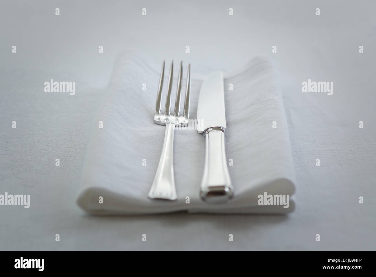 Messer und Gabel auf weißen Serviette Stockfoto