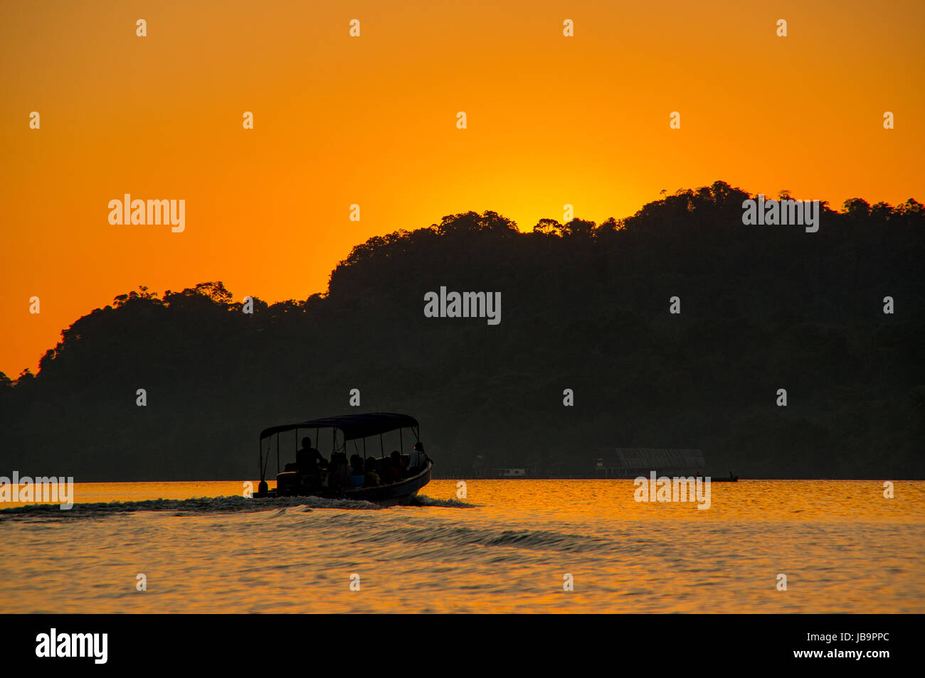 Blick auf ein Boot / Lancha bei Sonnenuntergang am Rio Dulce in Guatemala Stockfoto