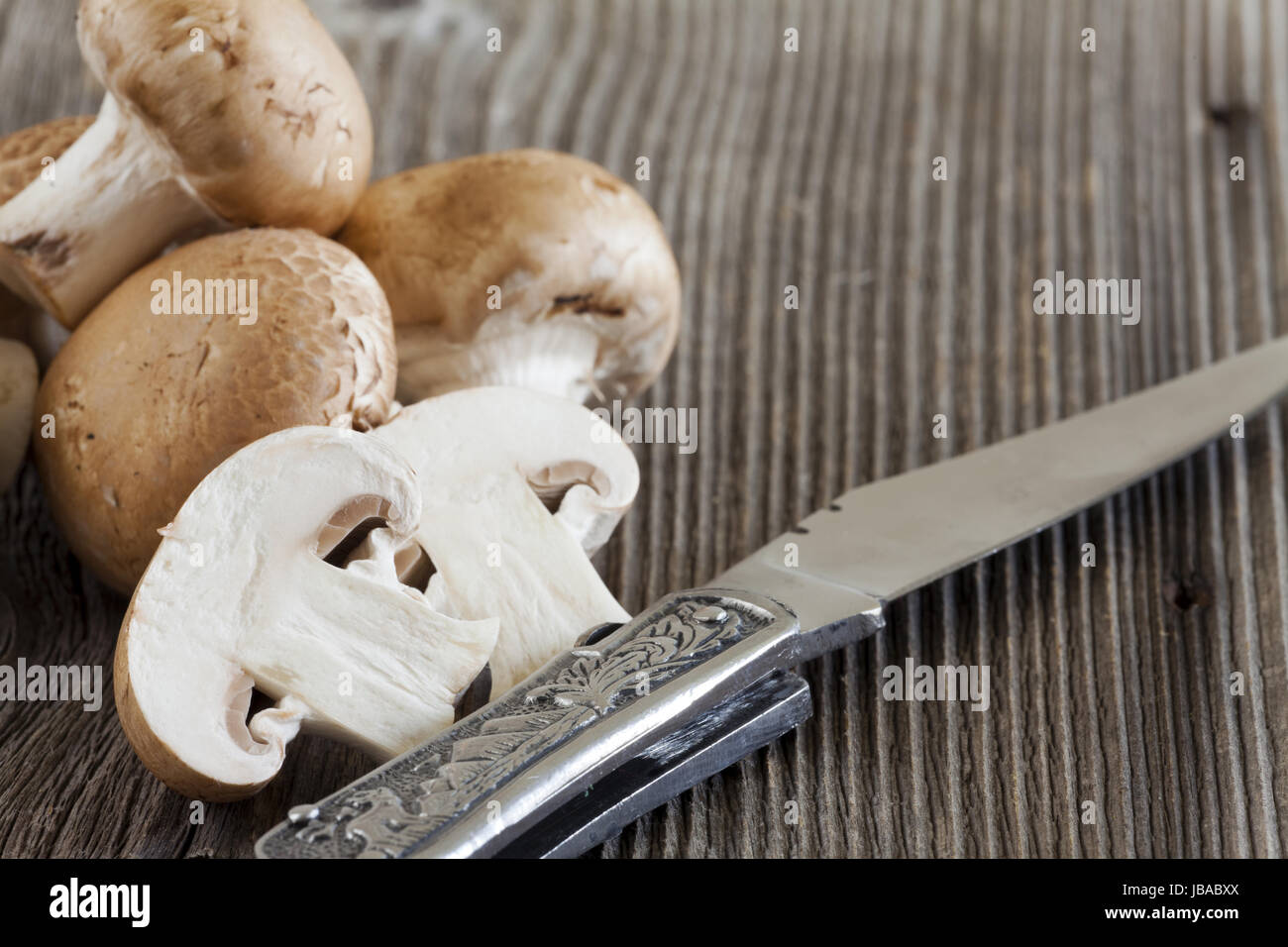 Pilze Und Ein Messer Auf Rustikalem Holzbrett Stockfoto
