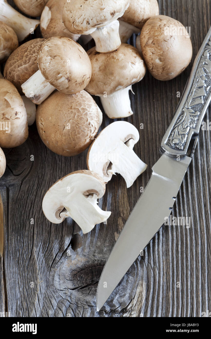 Messer Und Frische Pilze Auf Rustikalem Holzbrett Stockfoto