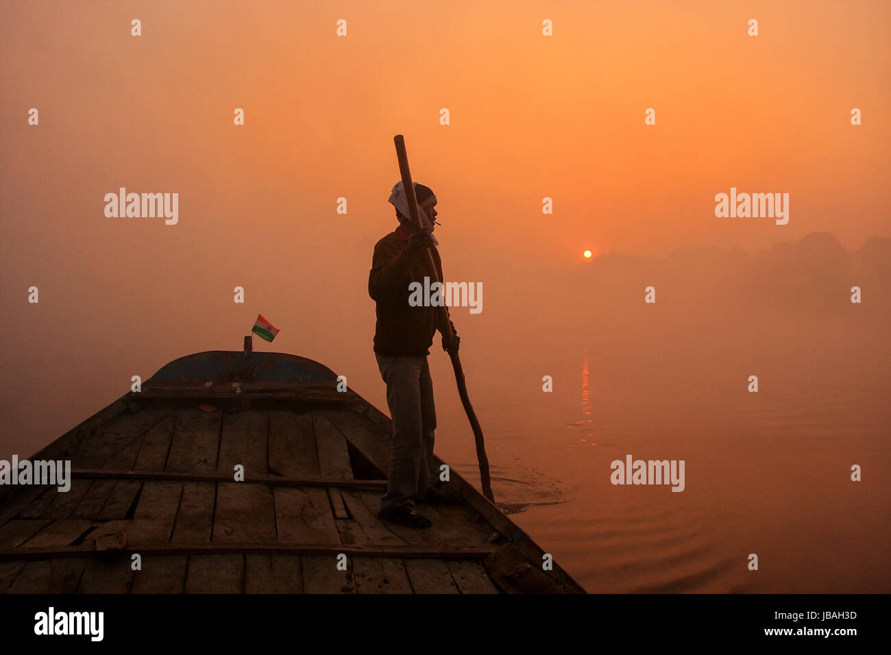 Lokale Mann weitergehen Boot Fluss Yamuna mit einem Pol bei Sonnenaufgang, Agra, Uttar Pradesh, Indien. Agra ist eine der bevölkerungsreichsten Städte in Uttar Pradesh Stockfoto