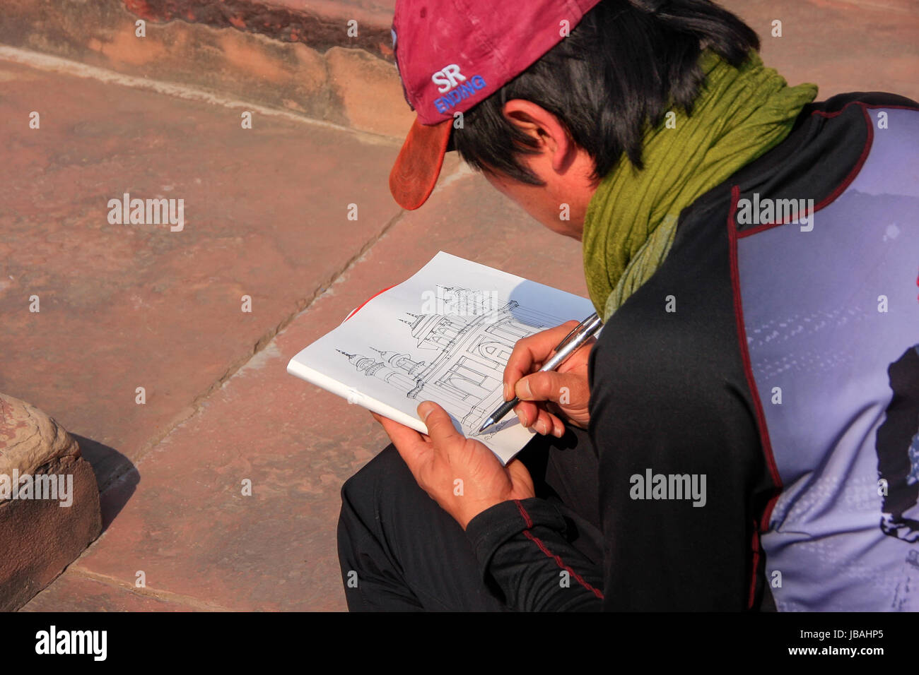 Mann, der eine Skizze des Itimad-Ud-Daulah Mausoleum, Agra, Uttar Pradesh, Indien. Dieses Grab wird oft als Entwurf des Taj Mahal angesehen. Stockfoto