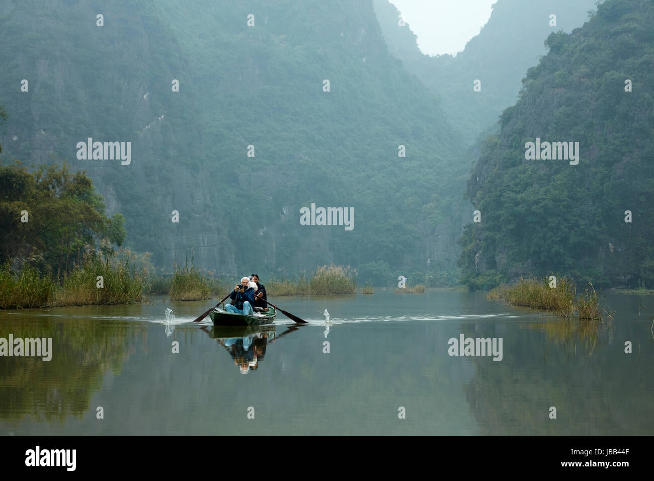 Touristen auf Tam Coc (drei Höhlen) Boot Reise auf Ngo Dong Fluss, (UNESCO World Herritage Area), in der Nähe von Ninh Binh, Vietnam Stockfoto