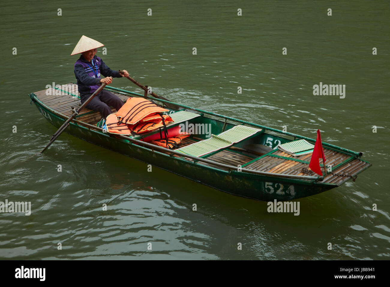 Frau im Touristenboot für Trang An Grotten Reise (UNESCO World Heritage Area), in der Nähe von Ninh Binh, Vietnam Stockfoto