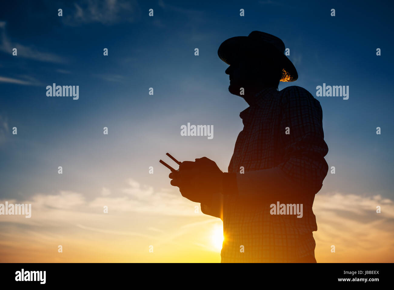 Silhouette der Landwirt mit Drohne Fernbedienung smart farming Landwirtschaft und die Zukunft der Landwirtschaft Stockfoto