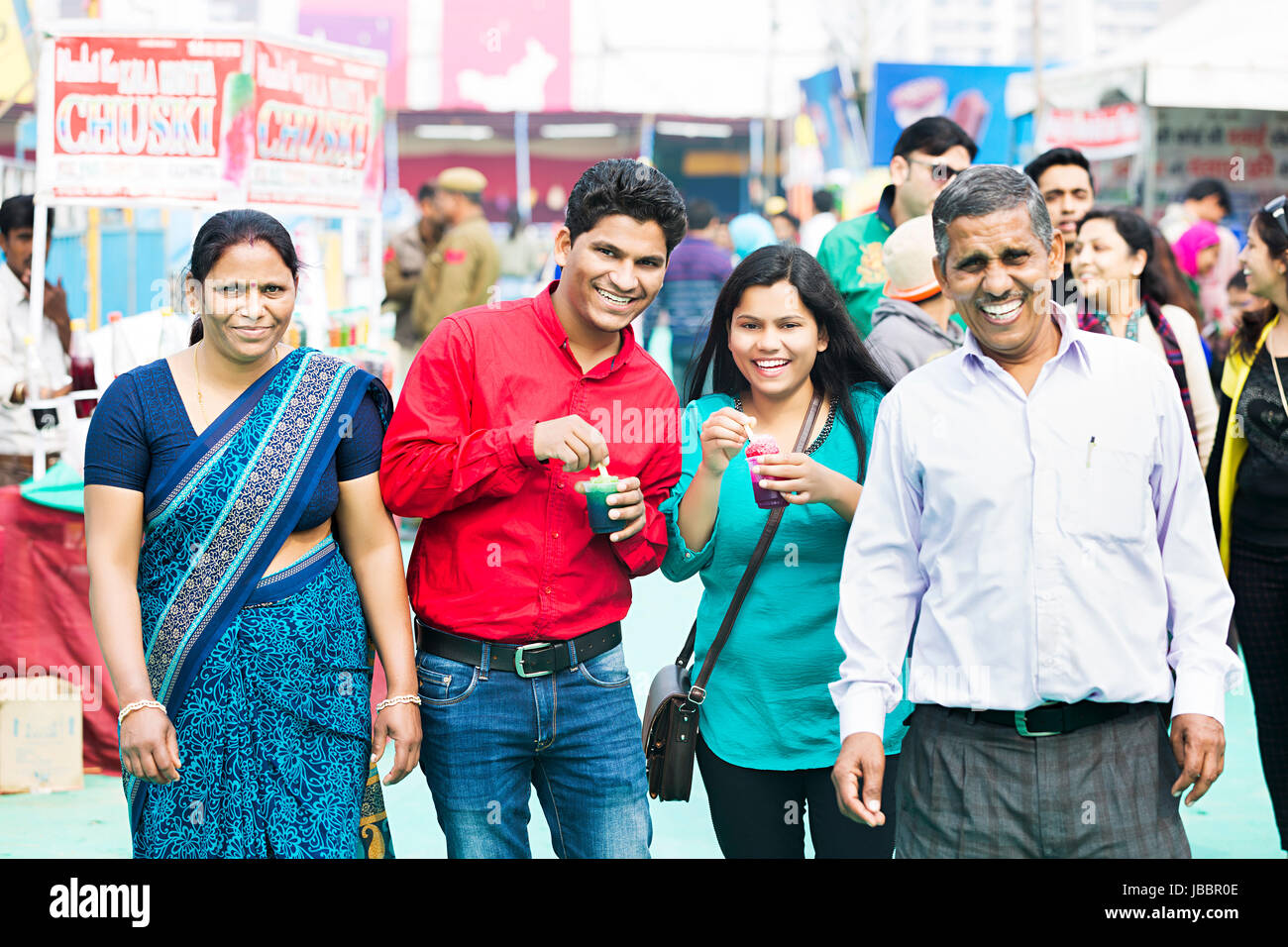 Gerne indische Familie essen Eis Candy Markt In Suraj kund Stockfoto