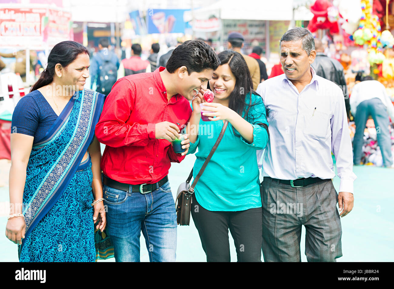 Gerne indische Familie essen Eis Candy Schwester Fütterung auf Bruder Messe in Suraj kund Stockfoto