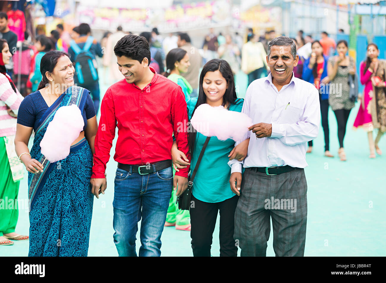 Happy indischen Eltern mit Sohn und Tochter gehen auf faire und Essen Zuckerwatte In Suraj Kund Stockfoto