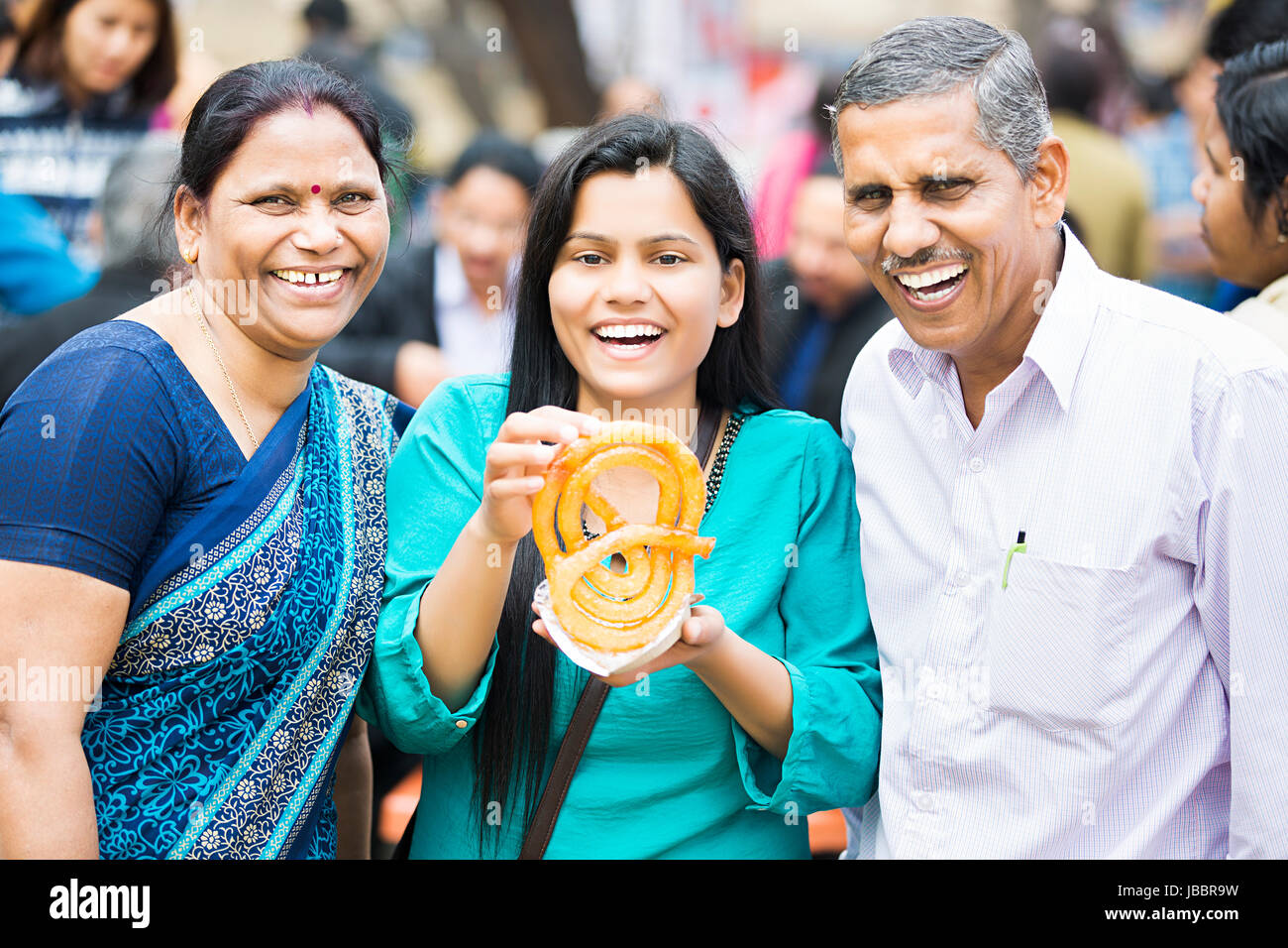 Gerne indische Familie Eltern und Tochter Essen Jalebi Messe in Suraj Kund Stockfoto