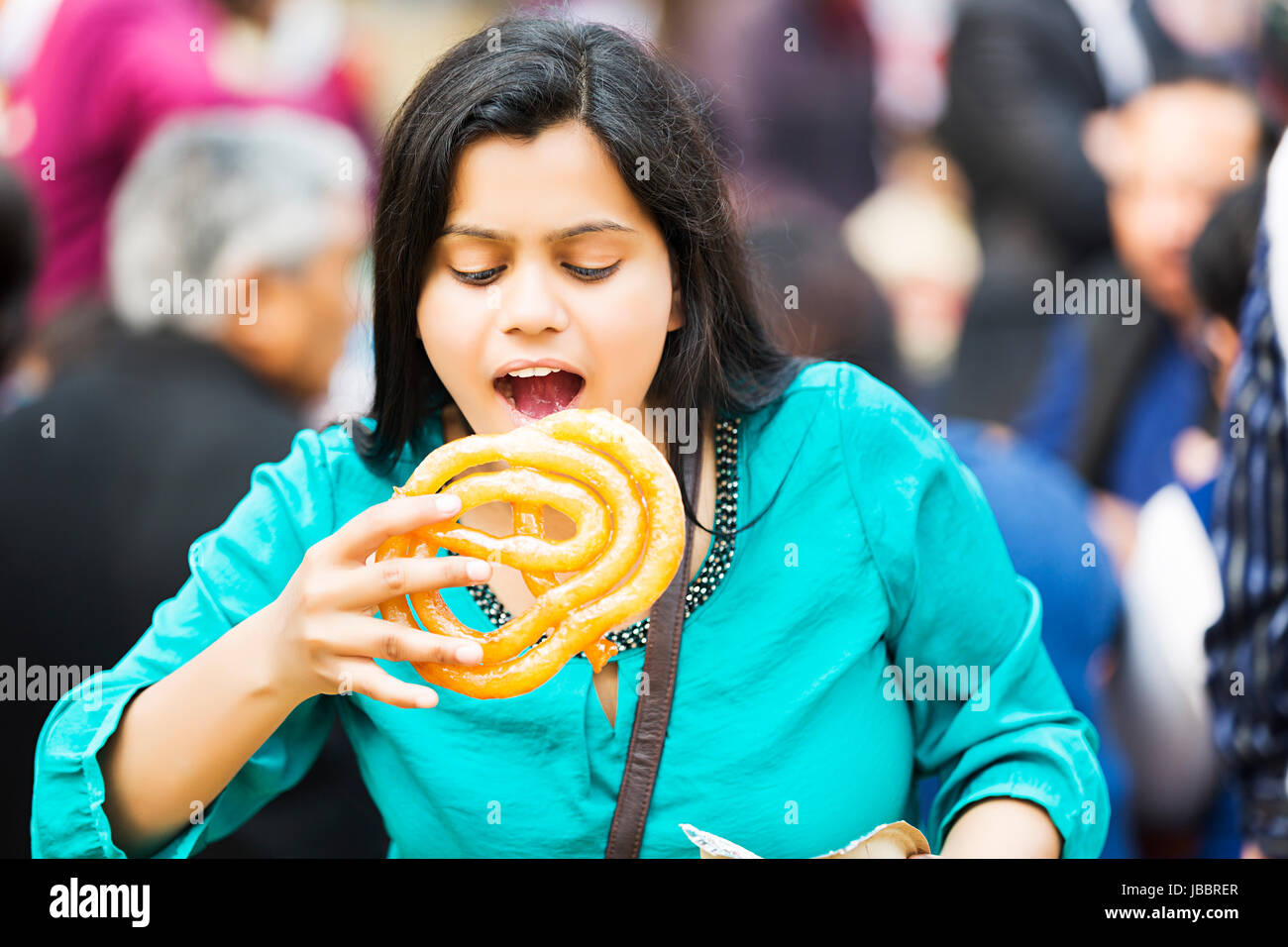 Happy 1 indische Junge Frau Essen Oversize Jalebi Markt In Suraj Kund Stockfoto