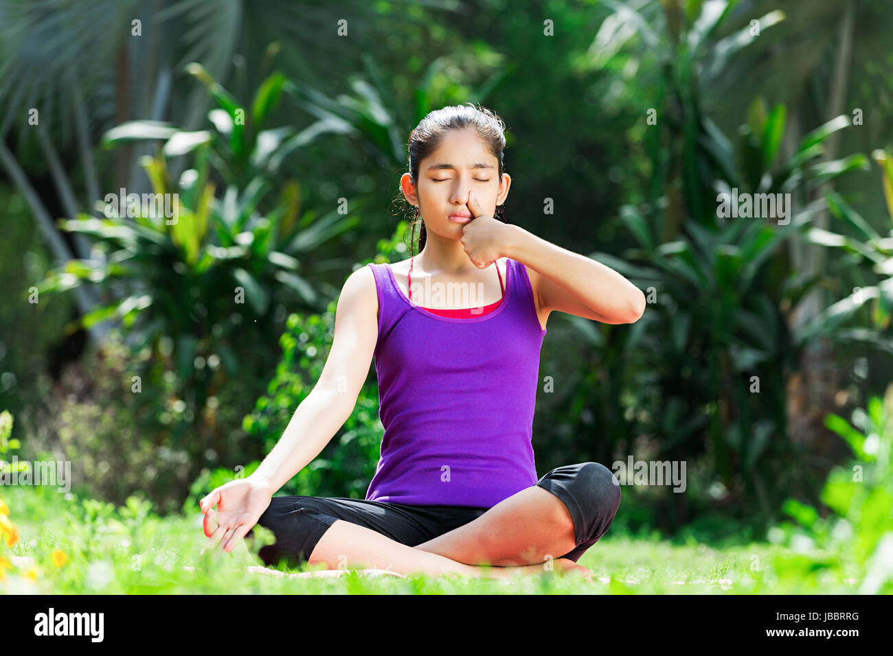 Ein indischer Jugendlicher Mädchen Meditation Yoga anulom vilom Übungen im Park Stockfoto