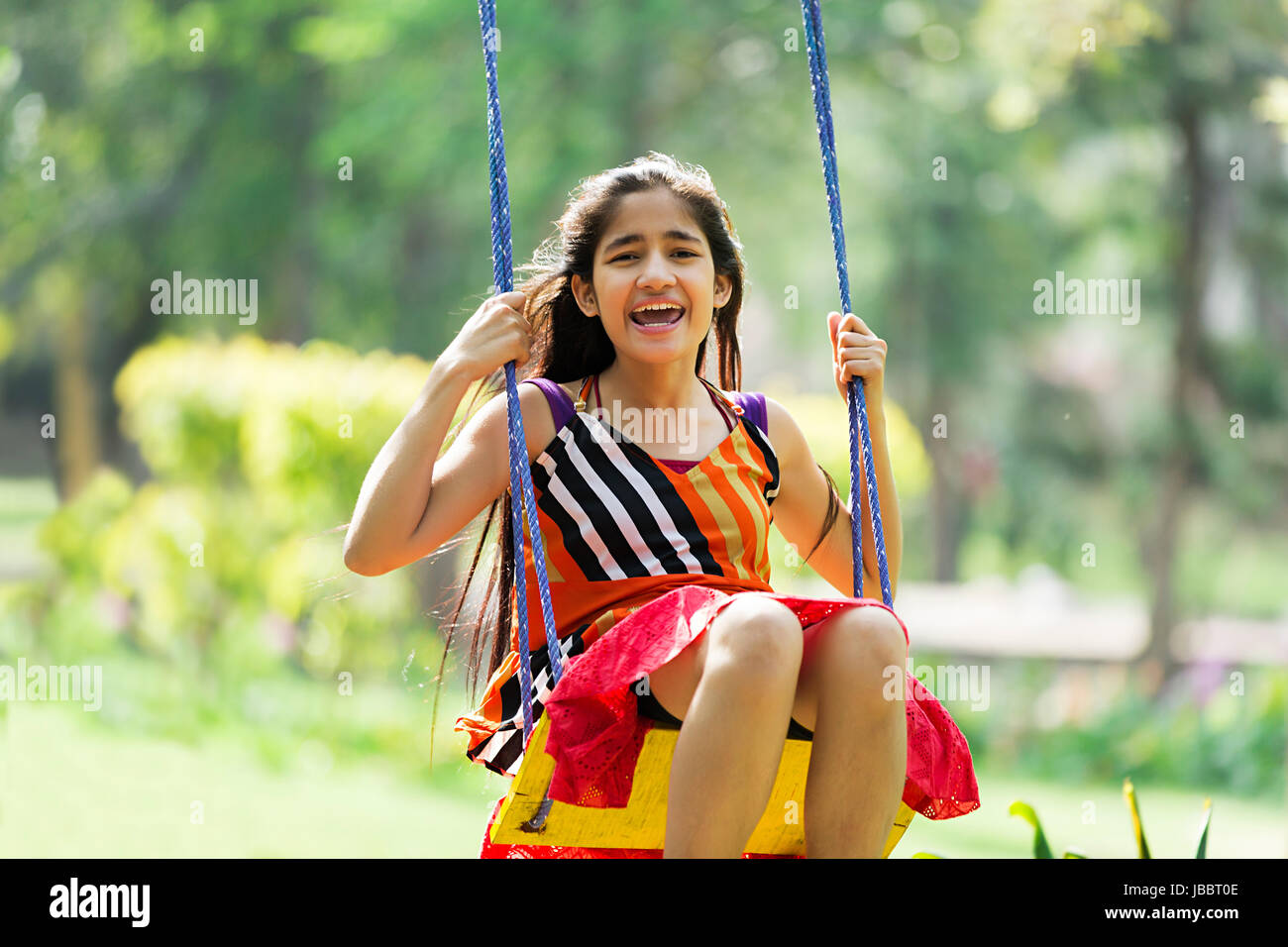 Glücklich, einem indischen jugendlich Mädchen Schaukel jhula in Park heiter Stockfoto