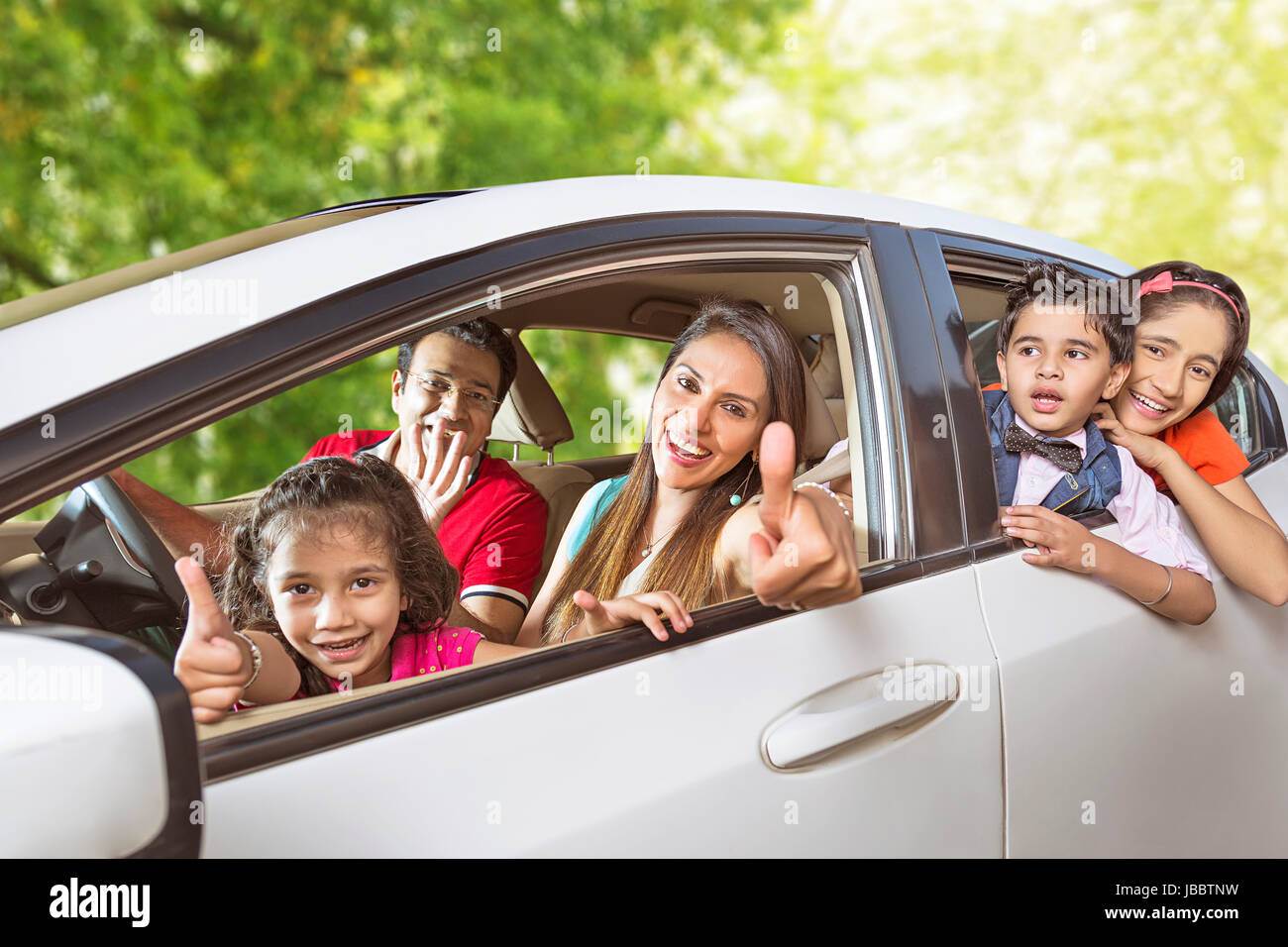 5 personen Auto Familie Reise Kinder Picknick sitzen lächeln Daumen hoch fahren Stockfotografie