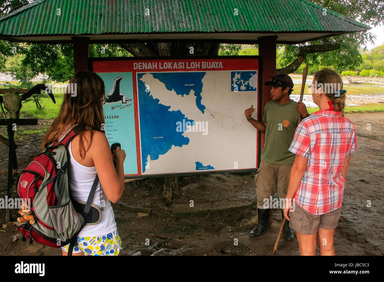 Führer im Gespräch mit Touristen am Visitor Center auf der Insel Rinca, Komodo National Park, Indonesien. 1991 wurde der Nationalpark ein UNESCO-Welt erklärt. Stockfoto