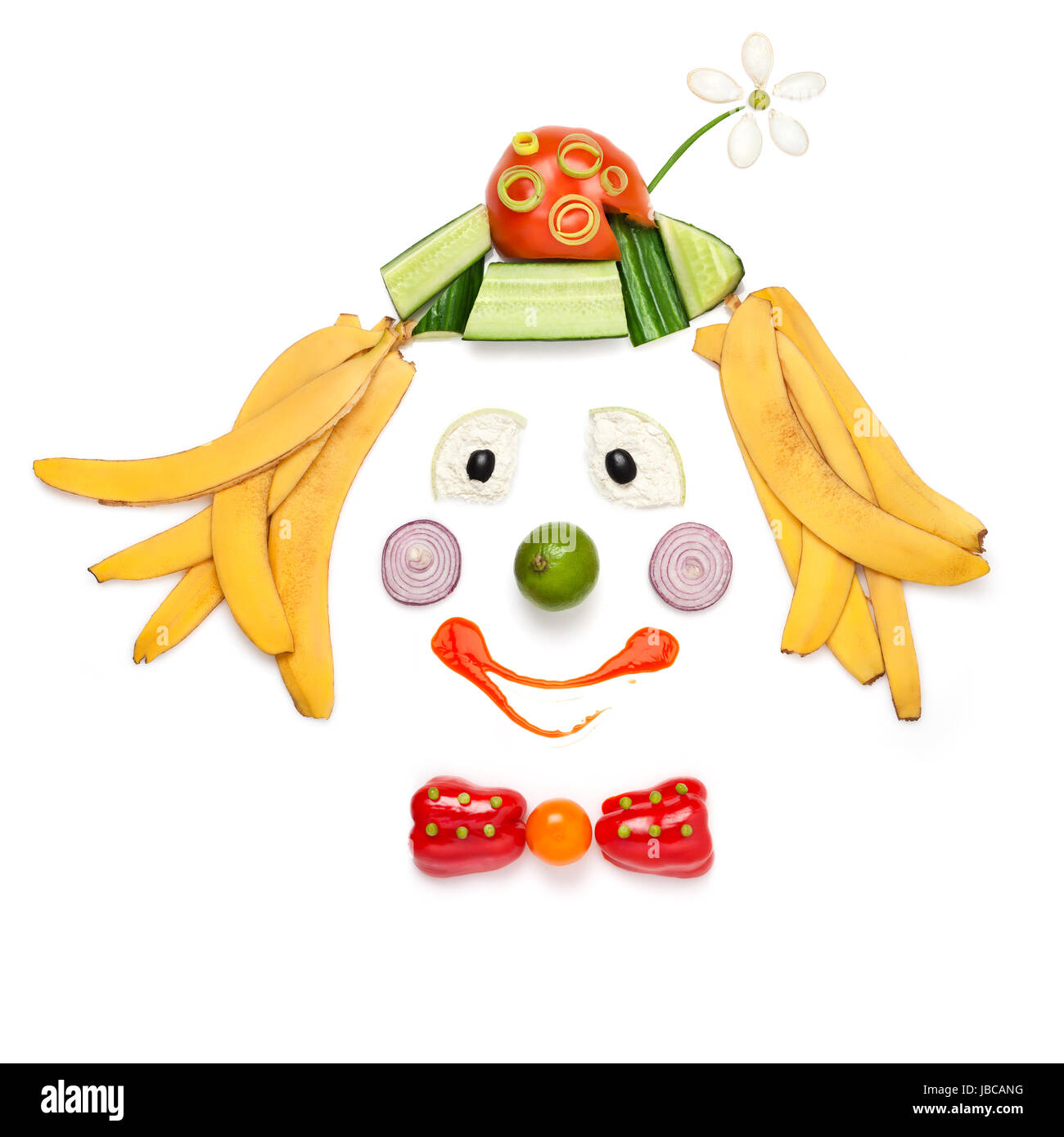 Ein kreativer Food-Konzept zeigt ein Porträt von lächelnden Clown von Obst und Gemüse in einem Menü für Kinder gemacht. Stockfoto