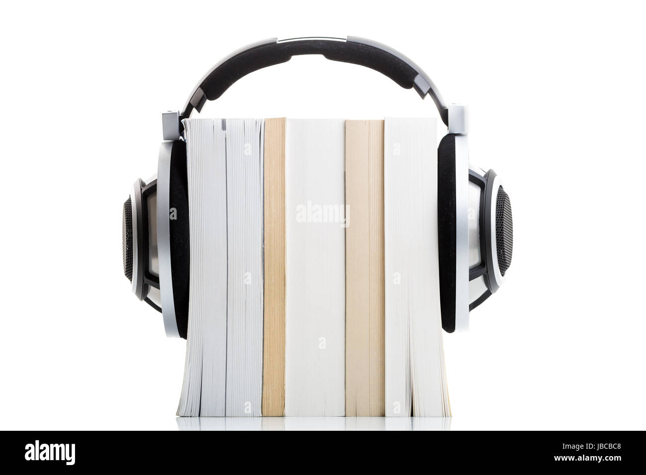 Hörbuch-Konzept - hören Sie Ihre Bücher in HD-Qualität; High-End-Hifi-Kopfhörer über mehrere Bücher auf weiß Stockfoto