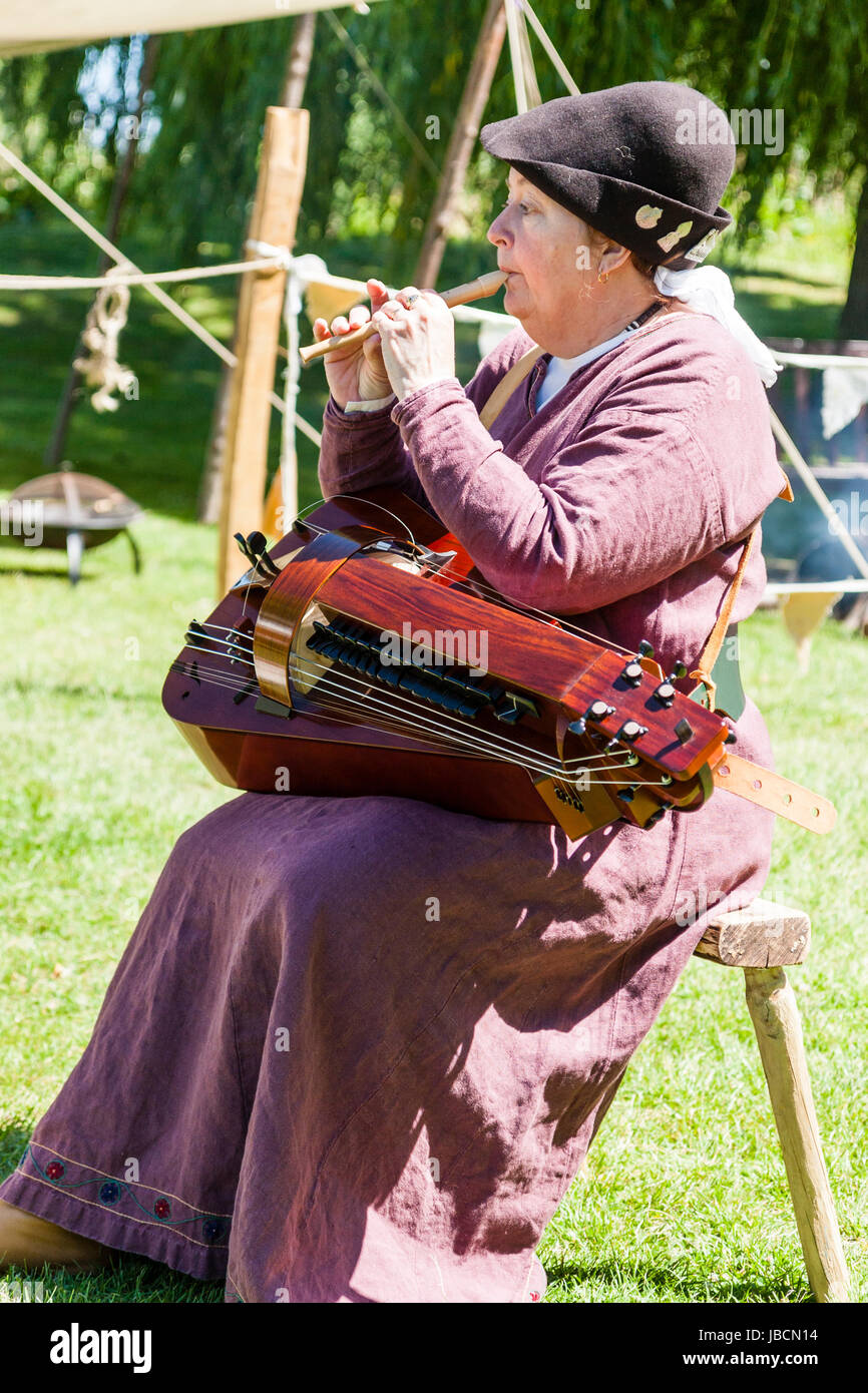 Mittelalterliche Re-enactment im Le Wochenende Veranstaltung, Sandwich Stadt. Reife Frau in lila Kostüm, Sitzen im Freien spielen kleine Flöte, Mitglied der rauhen Muiscke. Stockfoto
