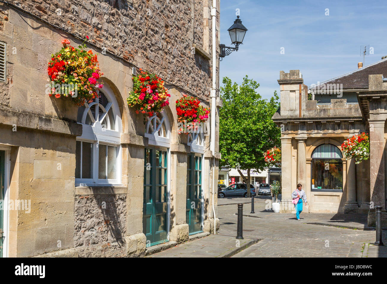 Das Rathaus in Brunnen auf dem gepflasterten Marktplatz steht und fällt im reizvoll Blumenschmuck im Sommer, Somerset, England, UK Stockfoto