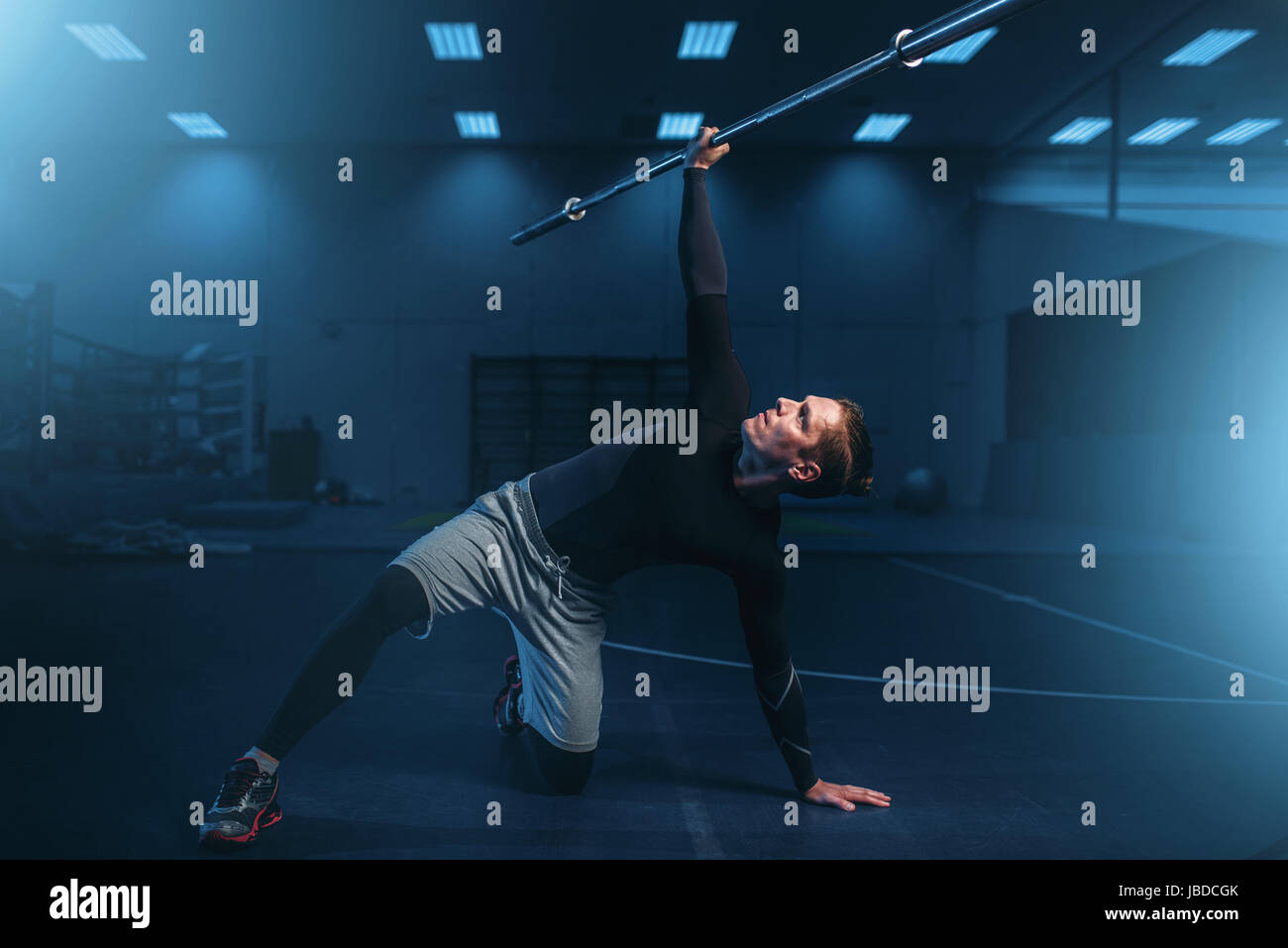 Sportlicher Mann auf training, Training mit Langhantel im Fitness-Studio. Aktive Übungen im Sportclub Stockfoto