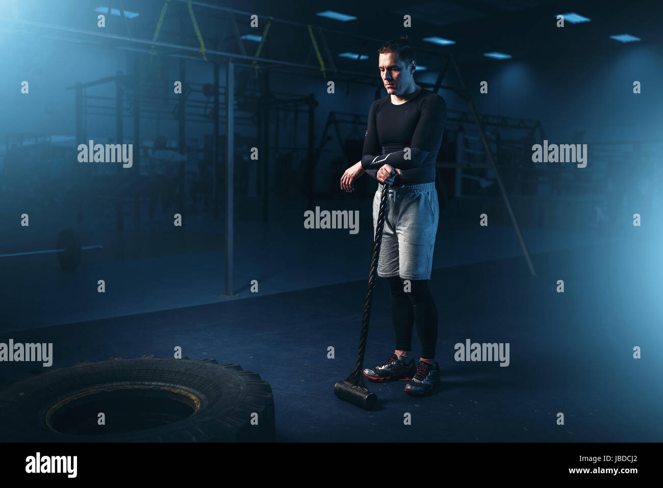 Training im Fitness-Studio, Mann mit Vorschlaghammer Hits Reifen. Aktive Bewegung im Sportverein Stockfoto