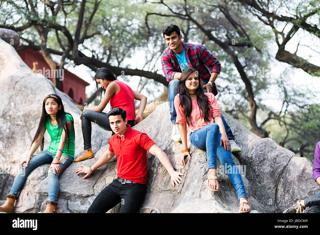Glückliche Gruppe Teenager Jungen Mädchen Freunde sitzen Rock genießen Surajkund Stockfoto