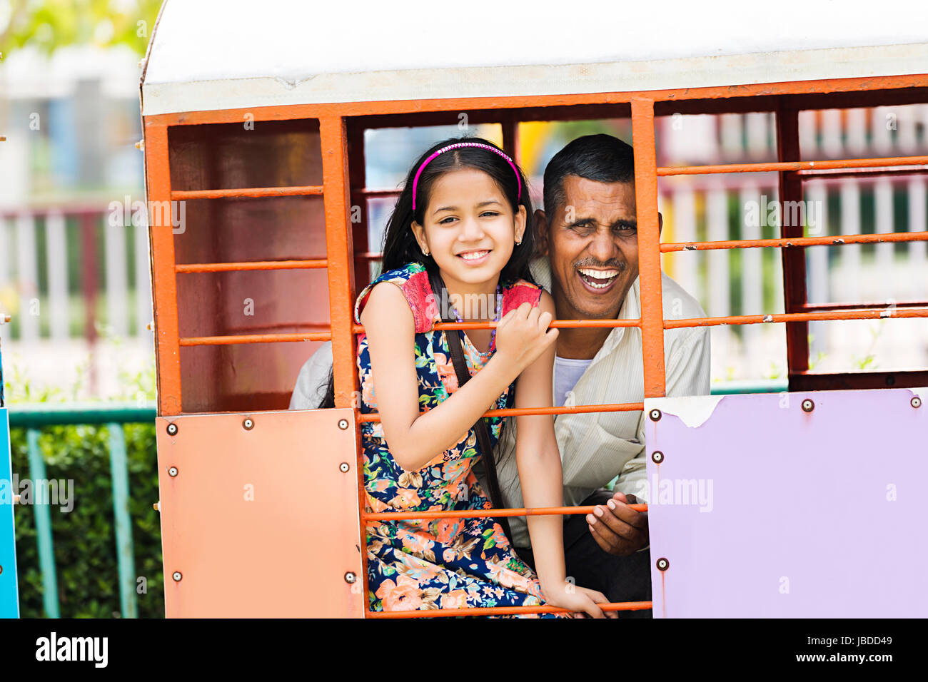 2 indische Großvater und Enkelin Vergnügungsparkfahrt Zug Spaß lächelnd Stockfoto