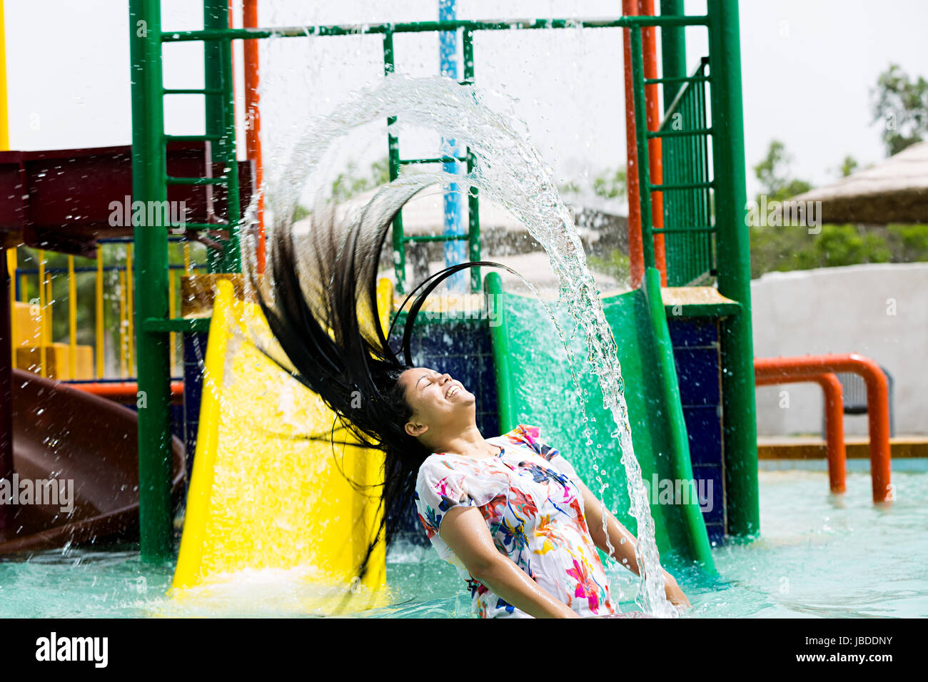 1 indischer Junge Frau Spritzwasser Schwimmbad Waterpark genießen Lächelnd Stockfoto