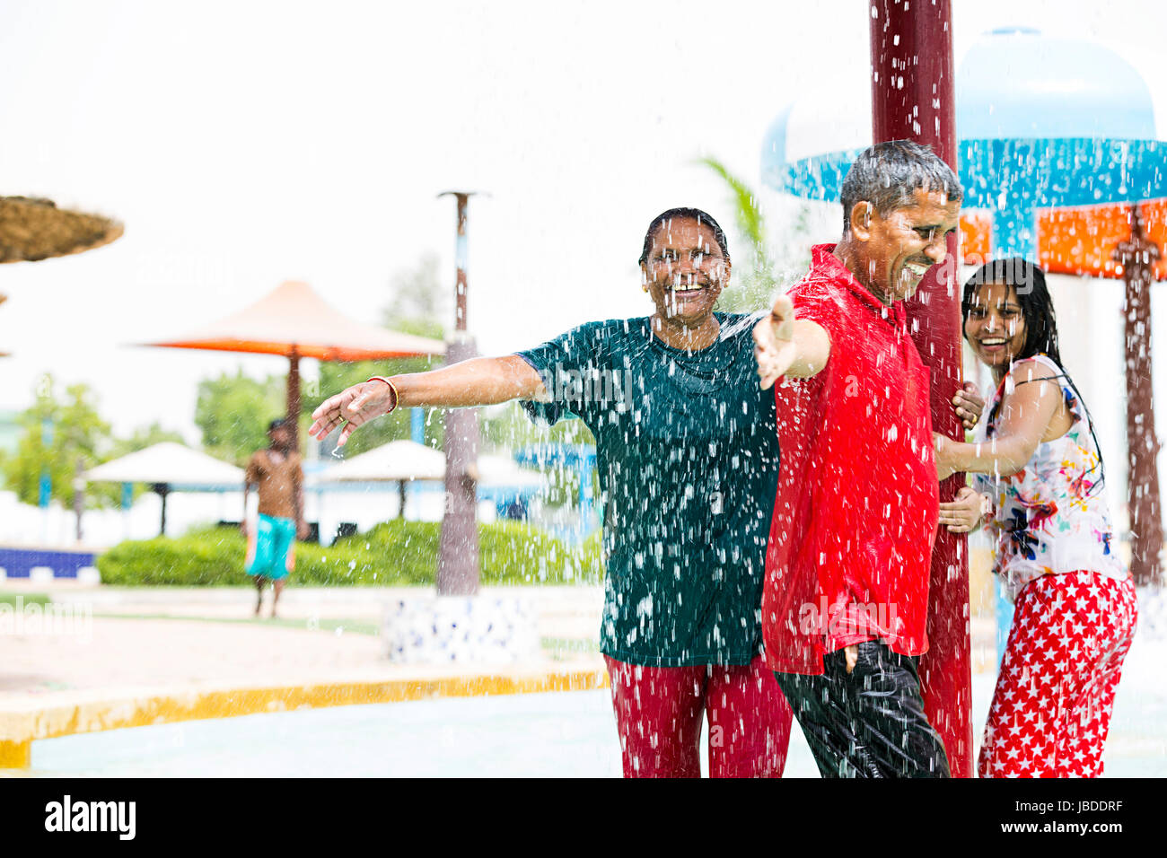 Happy indischen Eltern und Tochter rotierende Pole Baden Waterpark genießen Sie lächelnd Stockfoto