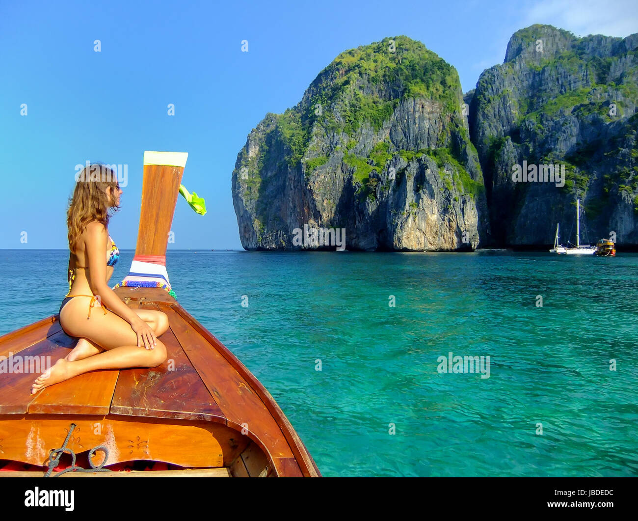 Junge Frau sitzt an der Vorderseite des Longtail-Boot in der Maya Bay auf Phi Phi Leh Island, Provinz Krabi, Thailand. Phi Phi Leh ist Teil des Mu Ko Phi Phi Na Stockfoto