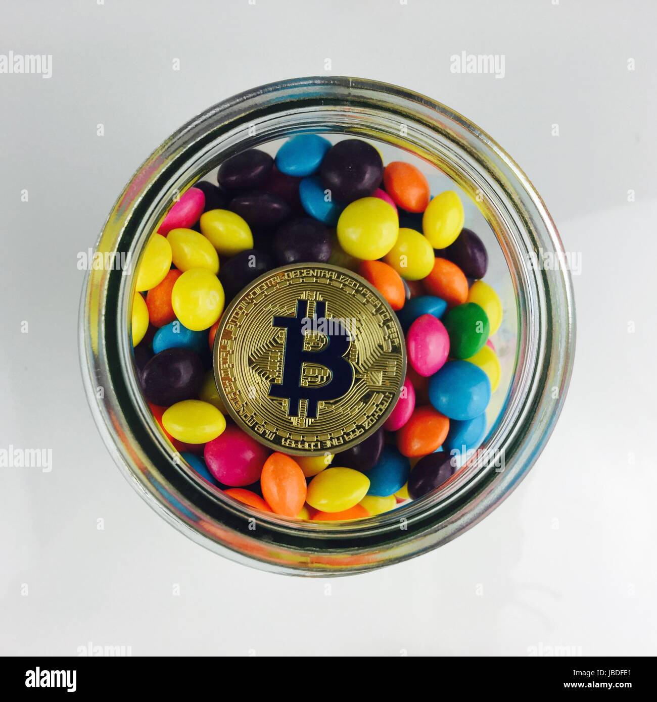 Digitale Währung physische gold Bitcoin Münze im Glas mit einem Süßigkeiten. Stockfoto