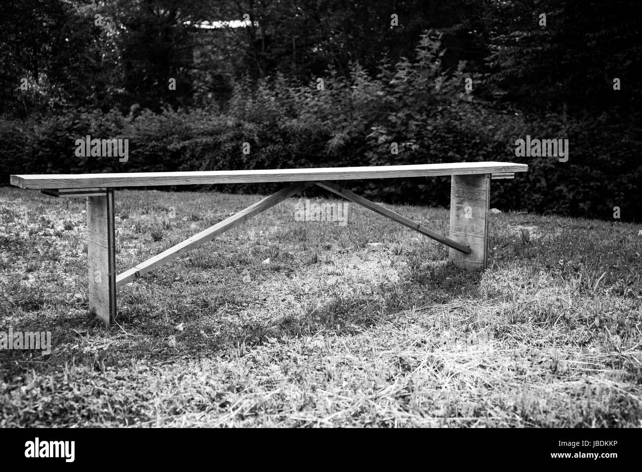 Eine Holzbank auf einer Wiese. Schwarz / weiß Stockfoto